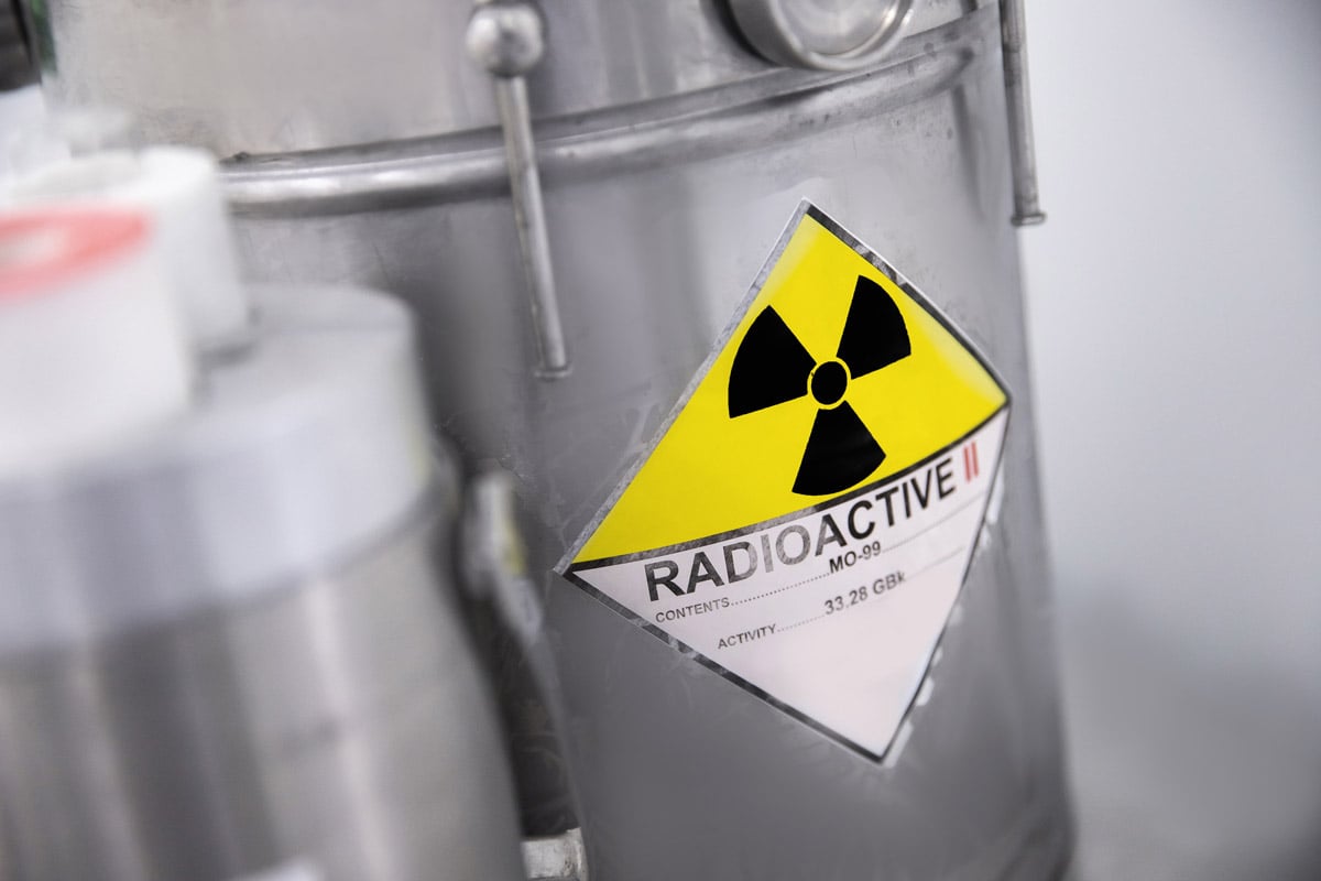 Metal container with a yellow radioactive hazard label indicating radioactive materials. 